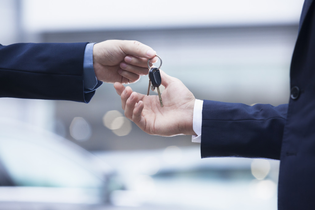 a car dealer handing keys to a buyer