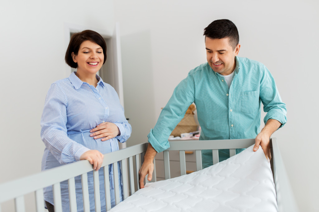 couple fixing the crib for their baby