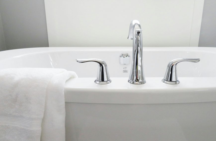 white ceramic bathtub with a faucet and two handles
